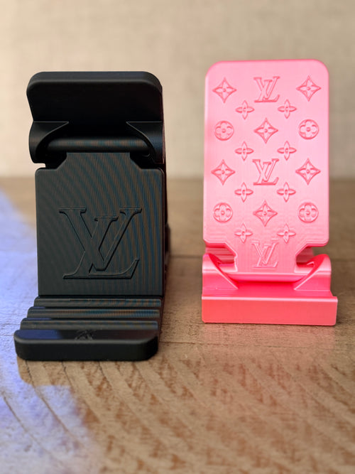 3D printed luxury monogram phone stands in hot pink and matte black side by side