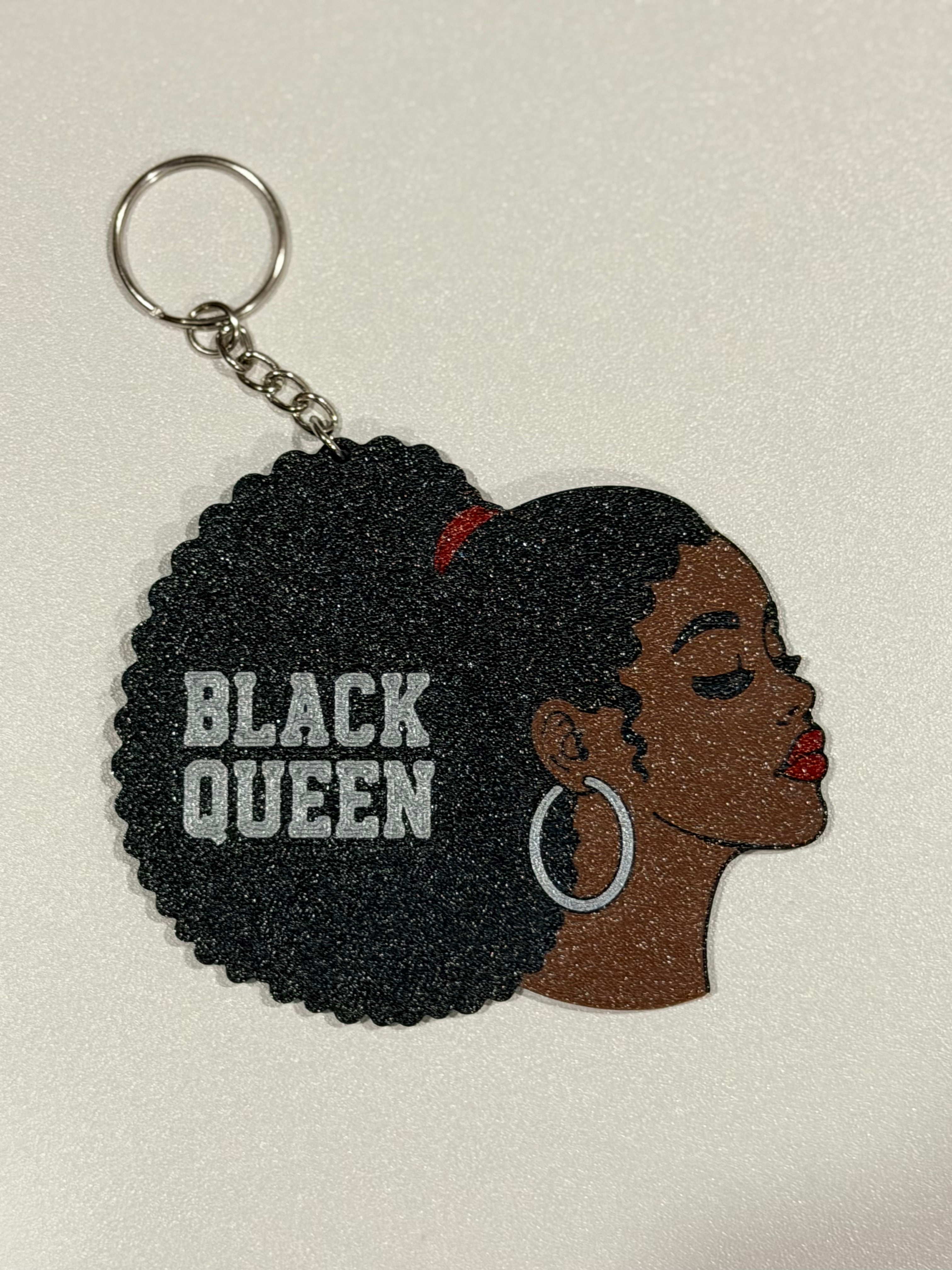Black Queen keychain on white background showing full design