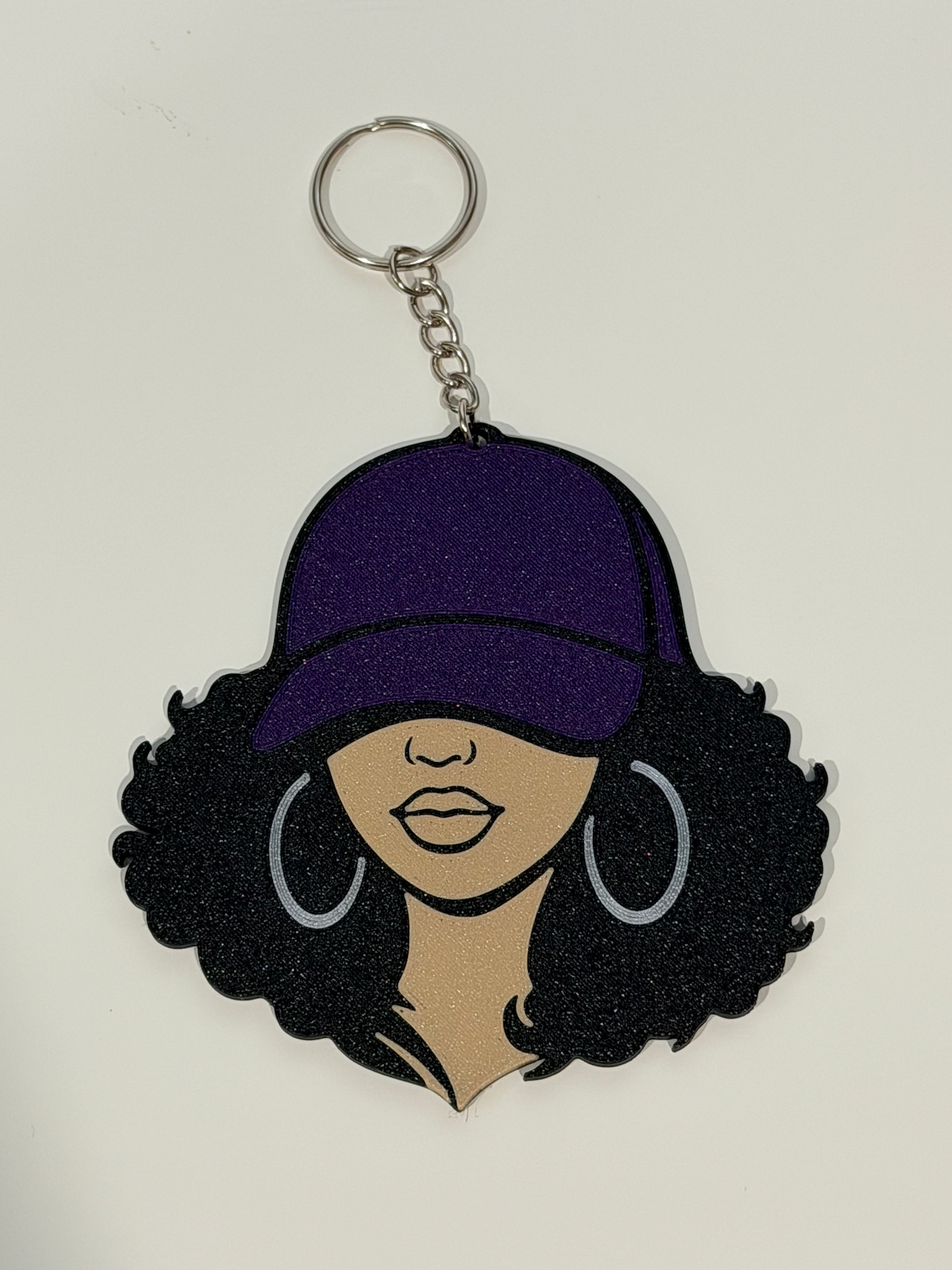 Curly Black Girl 3D Bag Charm with purple cap, voluminous curly hair and silver hoop earrings