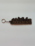 I'd Rather Be Reading 3D bag charm in cocoa-brown and black displayed on arch stand