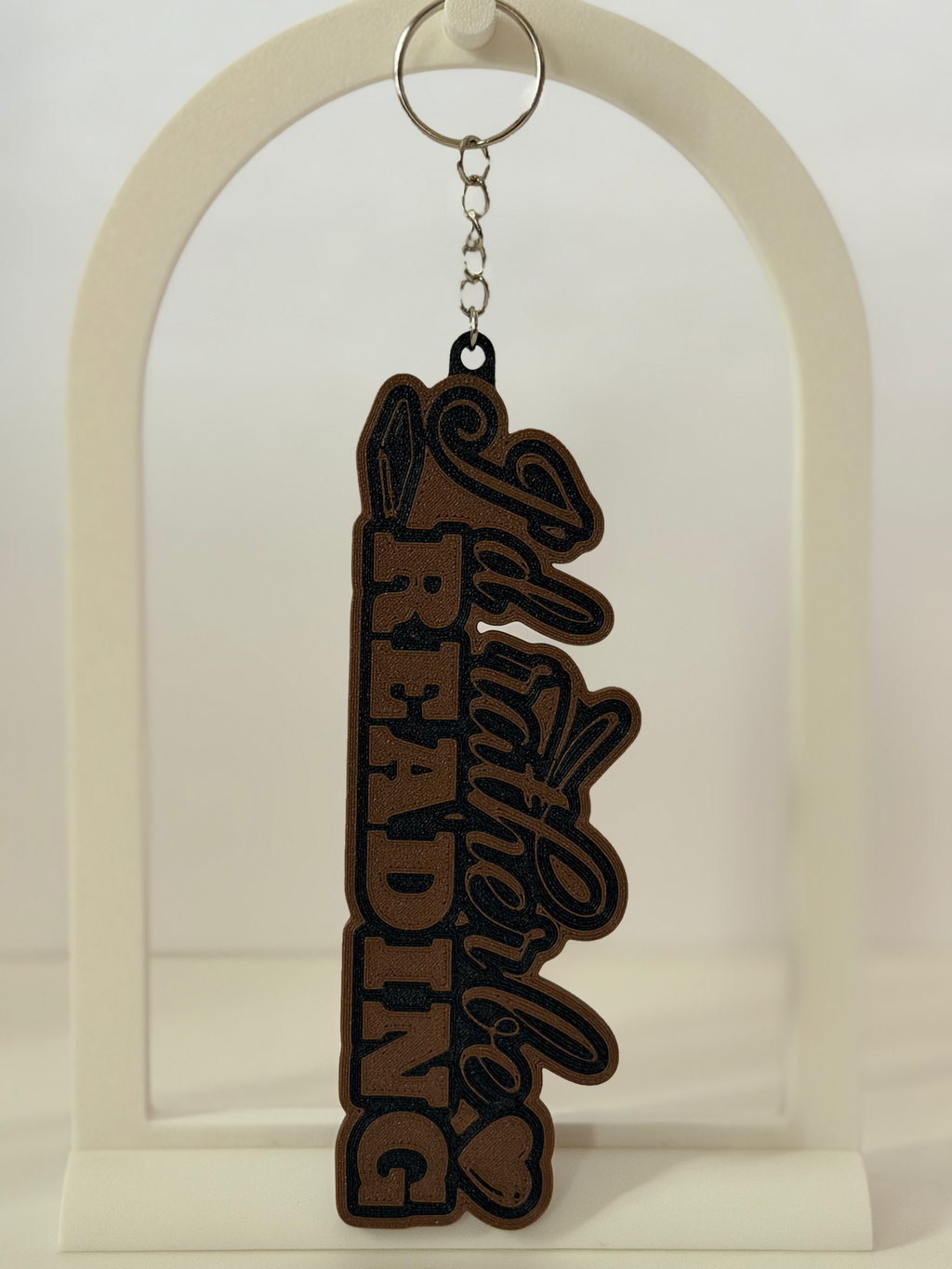 I'd Rather Be Reading 3D bag charm in cocoa-brown and black flat lay